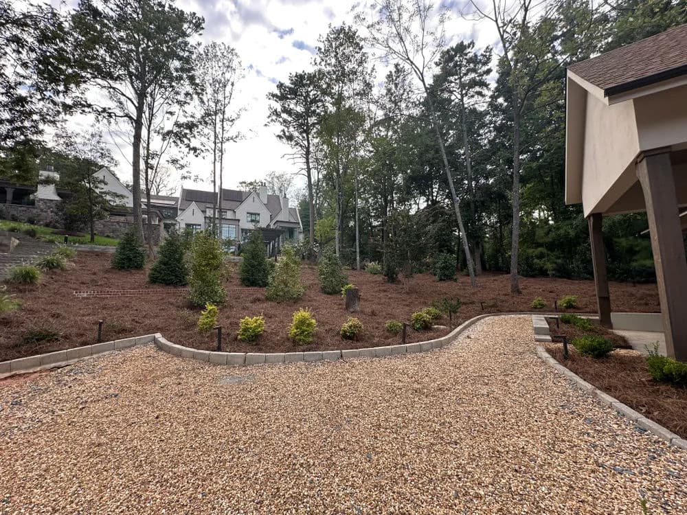landscaped backyard with gravel path, trees, and a home in the background, ideal for outdoor living